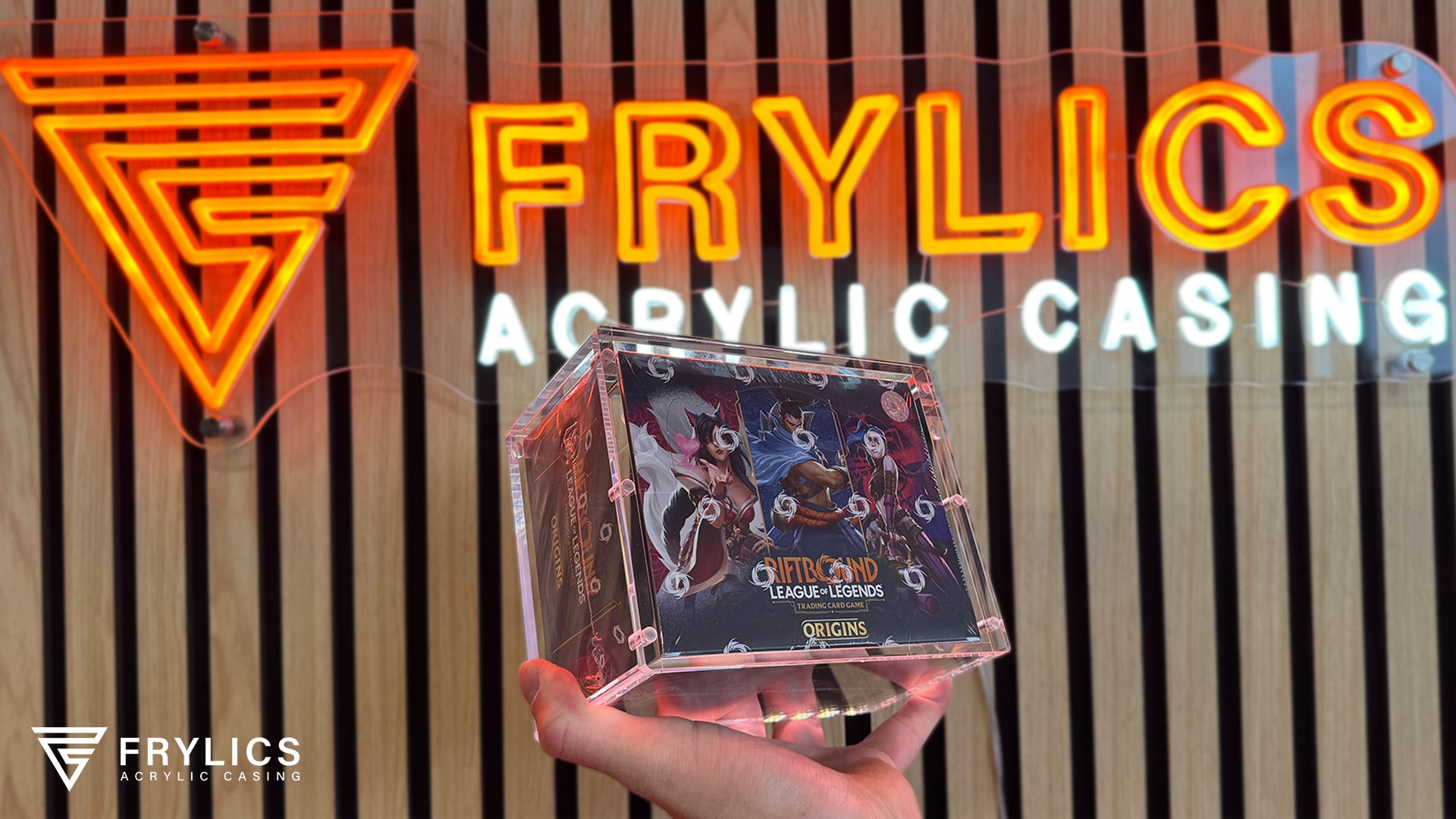 Riftbound Booster Box in Frylics Acryl Case sfeerfoto gemaakt voor Frylics logo op houten achterwand
